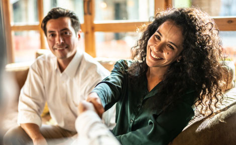 A woman shaking hands with someone out of frame