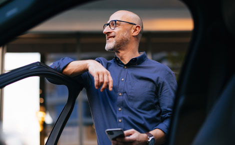 A man leaning agains a car door